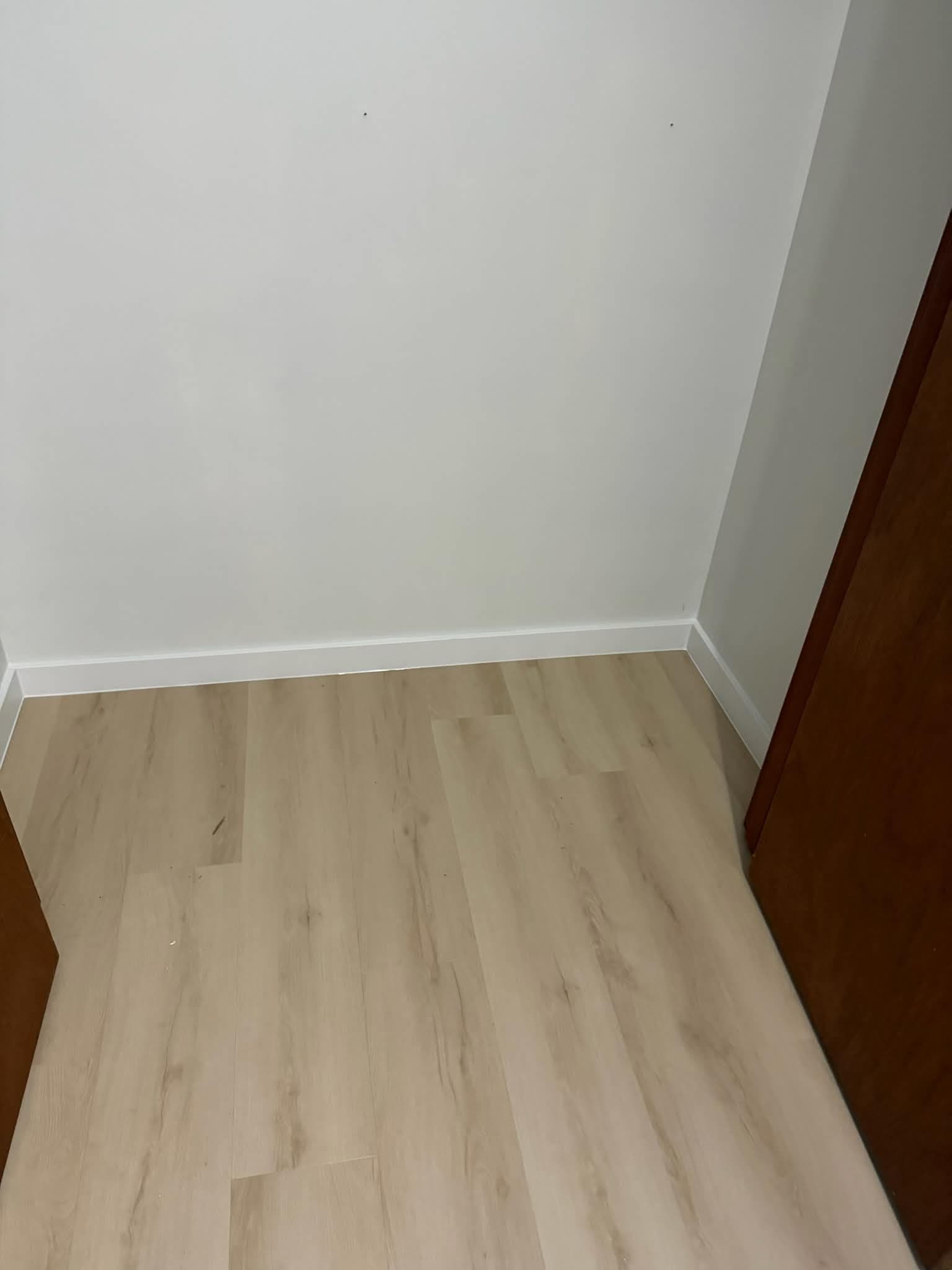 LVP flooring in closet with white baseboards