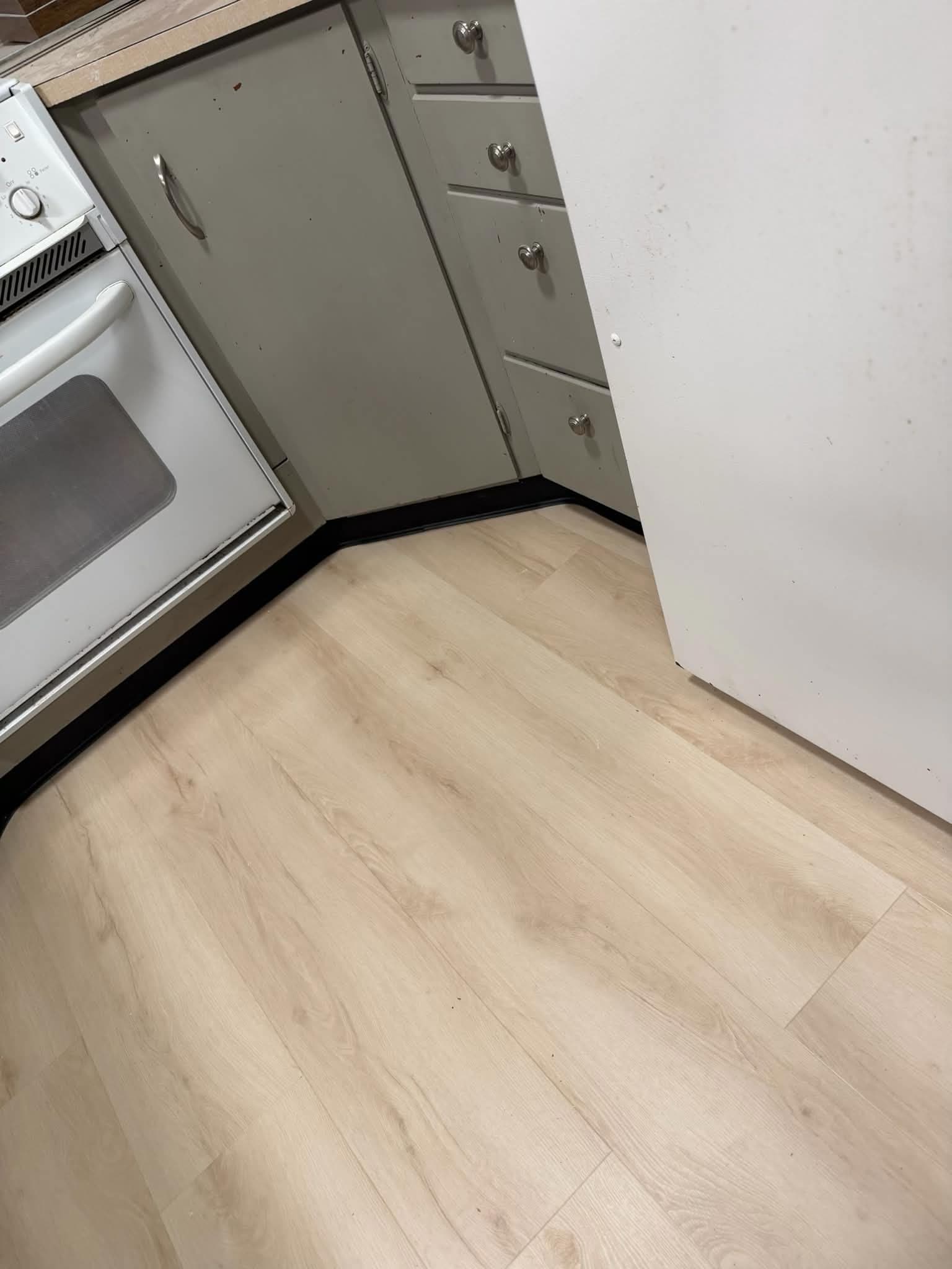 LVP flooring in kitchen with cabinets and oven
