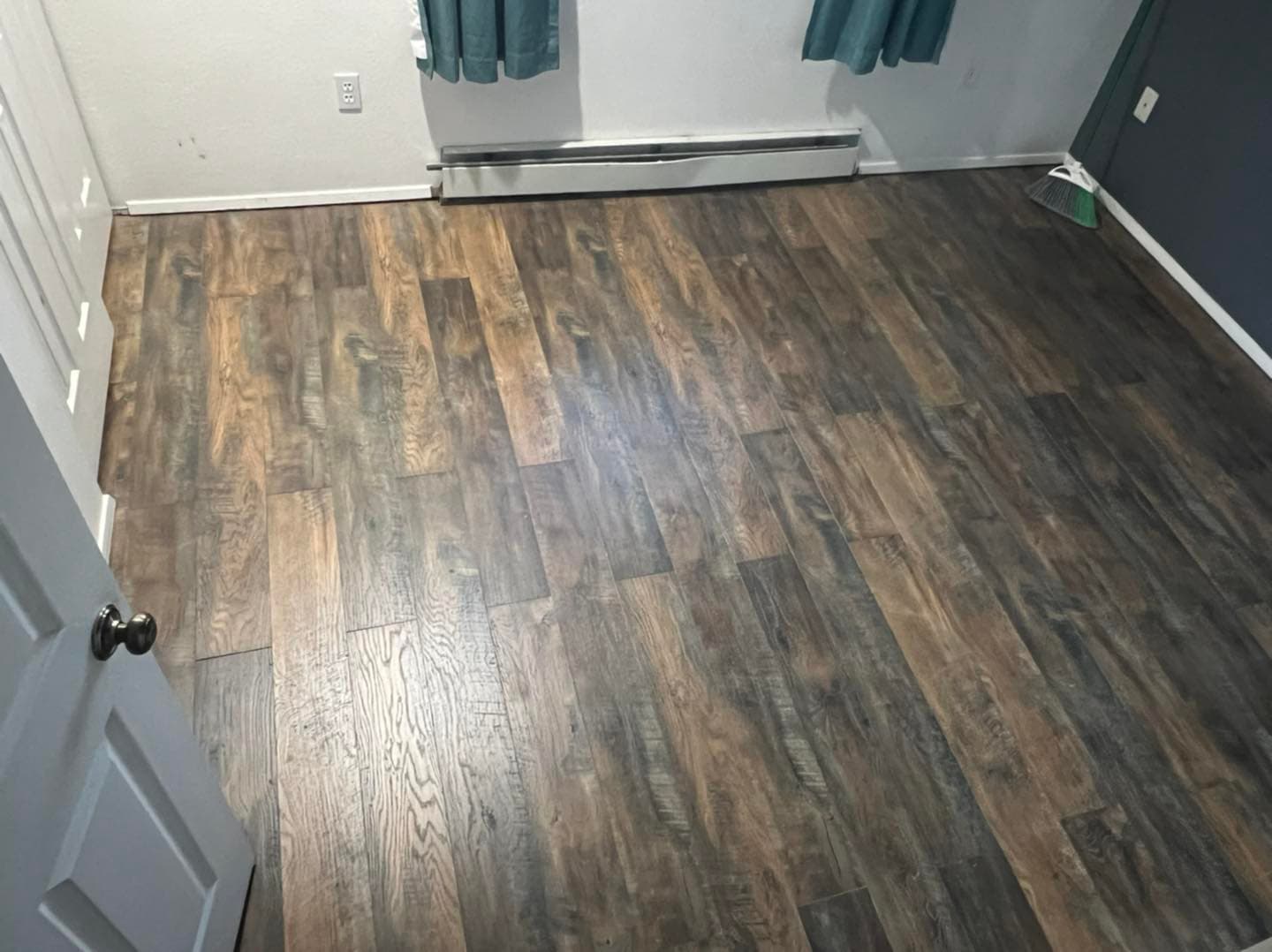 Dark hardwood-look flooring installed in Juneau bedroom by Sourdough Construction